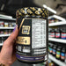 Close-up of (Dorian Yates DY Nutrition Blood And Guts 380g) held up inside My Supplement Shop, clearly showing Nutritional Values on the packaging in a Sports Nutrition setting.